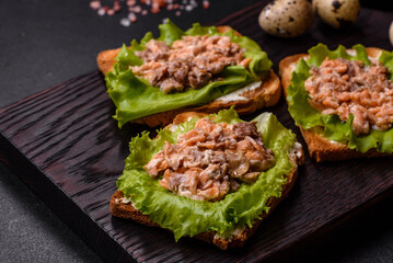 Delicious fresh sandwiches with toast, canned salmon, salad and quail eggs