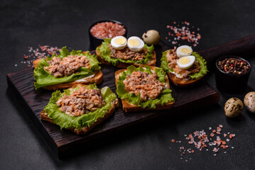 Delicious fresh sandwiches with toast, canned salmon, salad and quail eggs