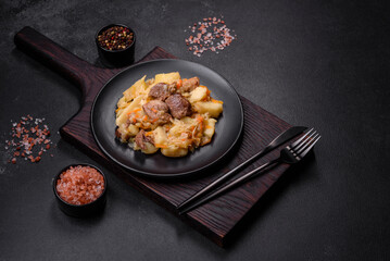 Delicious vegetable stew with beef, potatoes, carrots and cabbage in a black plate