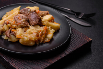 Delicious vegetable stew with beef, potatoes, carrots and cabbage in a black plate
