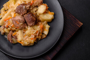 Delicious vegetable stew with beef, potatoes, carrots and cabbage in a black plate