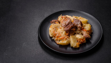 Delicious vegetable stew with beef, potatoes, carrots and cabbage in a black plate
