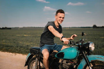 Fototapeta na wymiar man on a classic retro motorcycle in the village, nostalgia for retro technology.