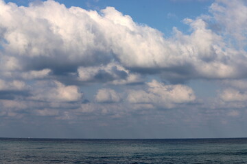 Naklejka na ściany i meble Large rain clouds in the sky over the sea.