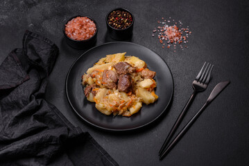 Delicious vegetable stew with beef, potatoes, carrots and cabbage in a black plate