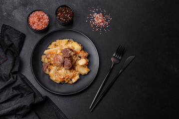 Delicious vegetable stew with beef, potatoes, carrots and cabbage in a black plate