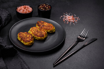 Diet vegetable cutlet from zucchini, carrot, herbs on a black plate
