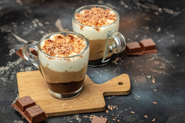 dessert three chocolates layer mousse, vanilla, chocolate, creme brulee on a dark background, place for text, top view