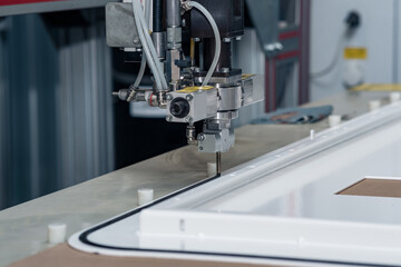 industrial robotic dosing dispenser machine applies a hardening sealant to the metal door blank