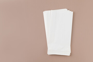 White empty Craft Paper bag for food on beige background. Mock up, blank. Place for text.