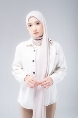 Half length portrait of a beautiful Muslim female model wearing modern and stylish casualwear with hijab isolated white studio background. Modern hijab fashion and beauty concept