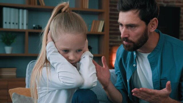 Sad offended little child daughter feel stress cover ears ignoring scream caucasian angry annoyed man dad shouting on girl for bad behavior and disobedience scolding kid problem of parenting in family
