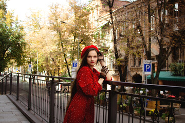 A girl in a red beret walks in the autumn city