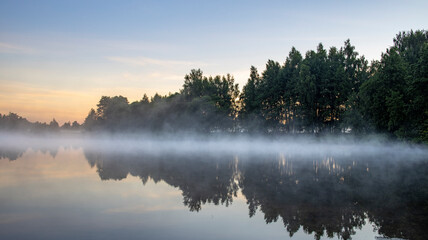 Obraz na płótnie Canvas Fog in the early morning. Dawn by the river.