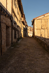 Cityscape with old, stone buildings in picturesque medieval town of Frias at sunset, Burgos, Spain