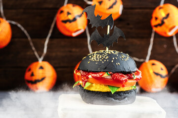 Halloween Spooky Black Burger with Cheese. Cheeseburger on Halloween pumpkin head jack lantern...