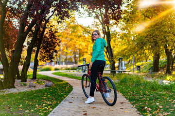 Obraz premium Woman riding bicycle in city park 