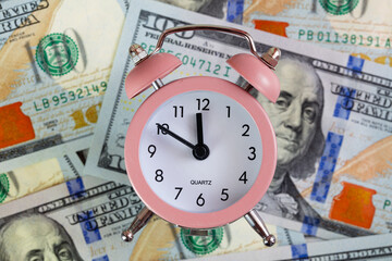 pink quartz alarm clock isolated on 100 dollar backgrounde