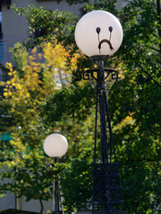 A lamp on a bridge with a smiley face daubed on it.