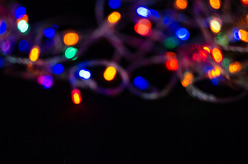 Colorful bokeh from a defocused garland on a black background