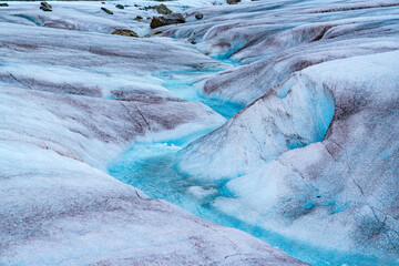 Melting glacier ice in the Mendenhall Glacier in Alaska forms a winding stream of crystal clear...