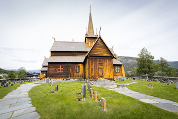 Fototapeta na wymiar A beautiful wooden stave church in Norway with a cemetery around