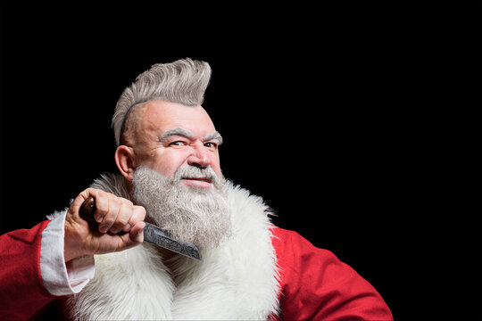 Freak santa wishes merry christmas and new year. Bad angry Santa Claus killer threatening with a knife. Santa in the form of a harsh punk. Unusual crazy Christmas