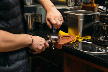 Unrecognizable barista placing coffee in a grinder