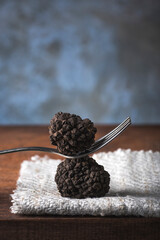 Black truffles with fork, rustic style, selective focus, macro. Season of black truffle. Autumn...