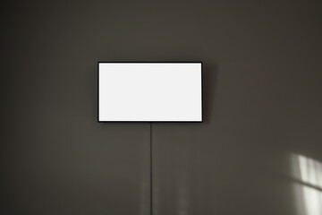Television screen in black frame with white mockup space hanging on concrete wall inside of room