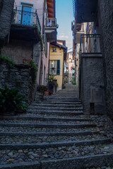Fototapeta premium Empty typical colorful street with rocky stairs and traditional mediterranean architecture in como, italy