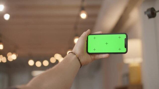 Iphone green screen mockup, holding phone landscape with trendy lights