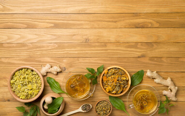 Fototapeta na wymiar Herbal tea with ingredients on wooden background, top view