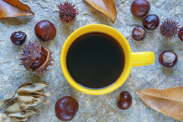 Naklejka na ściany i meble Autumn. Cup of coffee, autumn leaves and chestnuts on old stone table