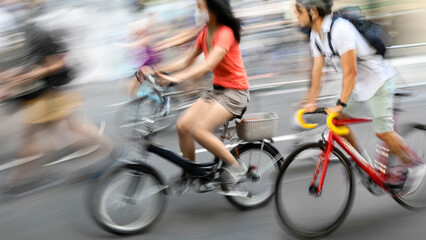 Fototapeta na wymiar Blurred silhouettes of cyclists on a city street