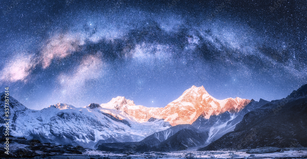 Wall mural milky way arch over snowy mountains at starry night in winter. landscape with snow covered high rock