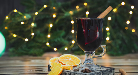 Glass of red wine mulled wine with cinnamon and orange on a cutting board on a table .