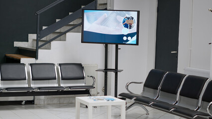 Hospital waiting room in facility lobby with empty chairs, healthcare center used to attend medical appointments and receive disease treatment. Waiting area with seats, insurance form and report.