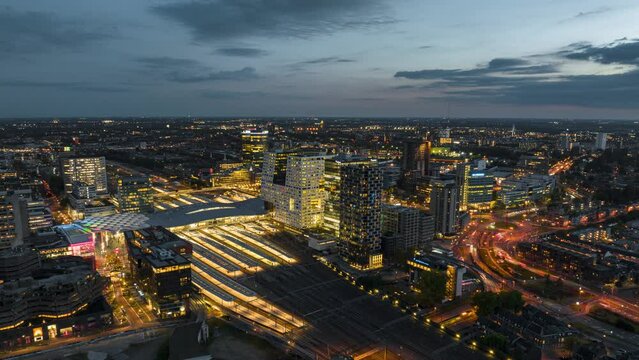 4k aerial time lapse of illuminated Utrecht central train station during rush hour with trains arriving and departing