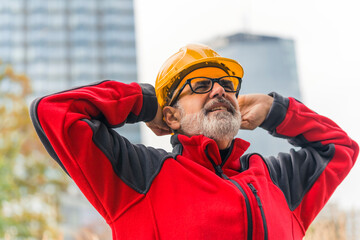 Male caucasian elderly construction worker with gray facial hair wearing bright red fleece and...