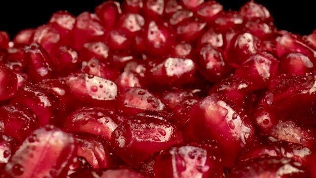Dolly shot of Pomegranate Seeds. This macro shot shows rotating translucent red pomegranate seeds.
