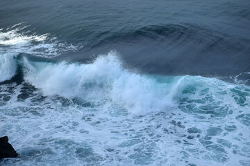 The waves crashing in the ocean, with a bluish tint at Drini Beach, Gunungkidul, Yogyakarta