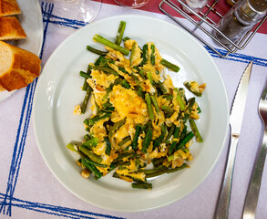 Fresh portion of scrambled eggs with green garlic and prawns.