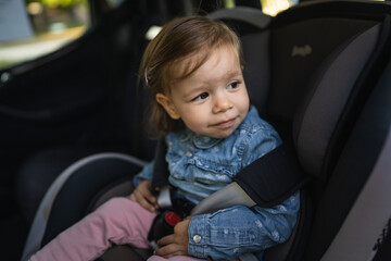 one small caucasian girl female toddler sit in the car safety seat