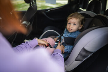 one small caucasian girl female toddler sit in the car safety seat
