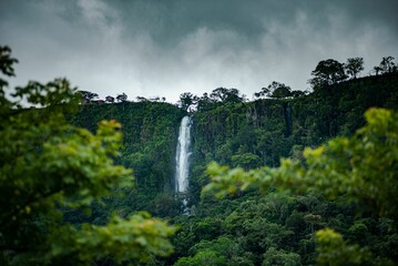 Fresh vegetation at Anton Valley in Panama with a waterfall and cloudscape - obrazy, fototapety, plakaty
