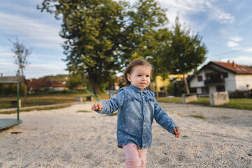 Portrait of one girl small caucasian female toddler child standing or walk alone outdoor in day childhood and growing up concept copy space