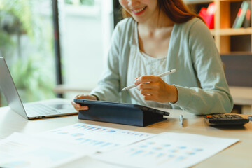 Beautiful young Asian businesswoman working at workspace.