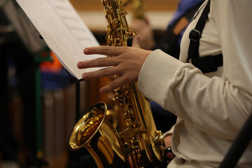 The person playing the saxophone fingers on the valve