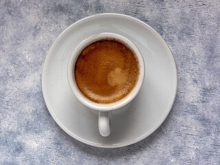 Cup of coffee   on a white textured surface.